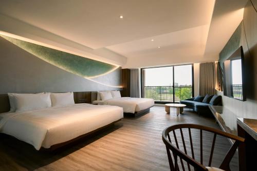 een hotelkamer met 2 bedden en een bank bij XIUXI Anping Hotel in Anping