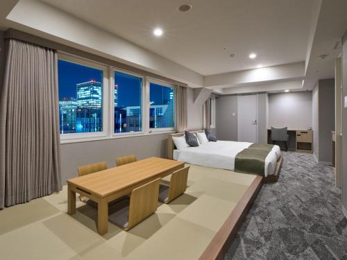 sypialnia z łóżkiem, biurkiem i stołem w obiekcie Hotel Villa Fontaine Tokyo-Otemachi w Tokio