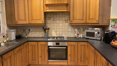 a kitchen with wooden cabinets and a stove top oven at Mixed dormitory shared with other guests in Dublin