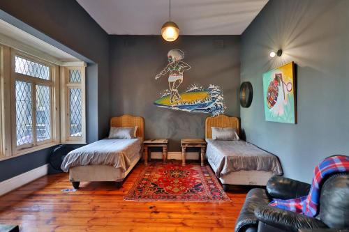 una sala de estar con 2 camas y una pintura en la pared en Soul House, en Durban