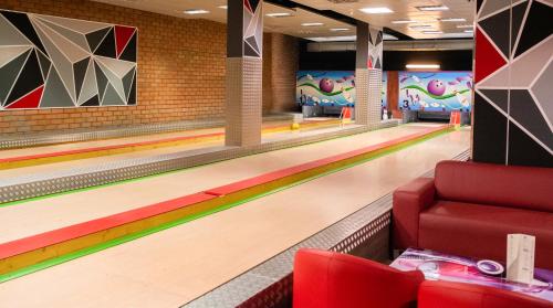 a bowling alley with lanes and a red chair at Hotel Princesa Parc in Arinsal