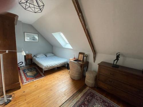 Zimmer im Dachgeschoss mit einem Bett und einer Kommode in der Unterkunft Maison spacieuse avec jardin, vélos et salle de sport in Saint-Brieuc
