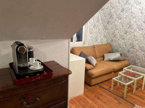 ein kleines Wohnzimmer mit einem Sofa und einem Tisch in der Unterkunft Maison spacieuse avec jardin, vélos et salle de sport in Saint-Brieuc