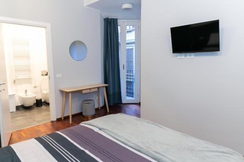 a bedroom with a bed and a television on a wall at sweet house deluxe in Milan