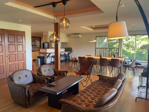 a living room with a couch and chairs and a table at New open【Mermaid annex】最大13名可！壮大な富士山の景色を楽しむ、高級貸別荘！ in Oishi