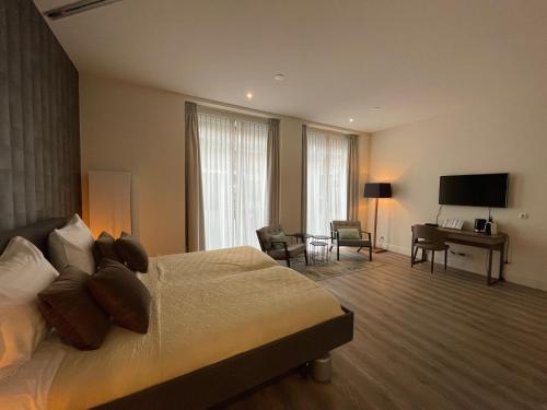 Habitación de hotel con cama, escritorio y TV. en Woonlandschap De Leyhoeve Groningen, en Groninga