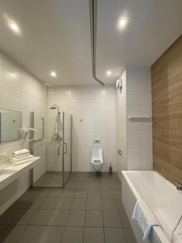 een badkamer met een douche, een toilet en een wastafel bij Woonlandschap De Leyhoeve Groningen in Groningen