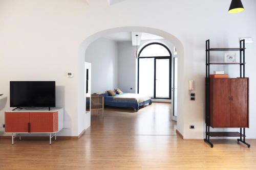 a living room with a bed and a television at ComeCasa Bright City Flat with Private Terrace in Milan