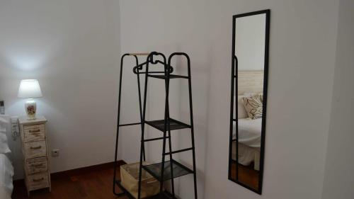 a room with a mirror and a shelf next to a bed at Mahonia Palacio Congresos Parking Concertado in Granada