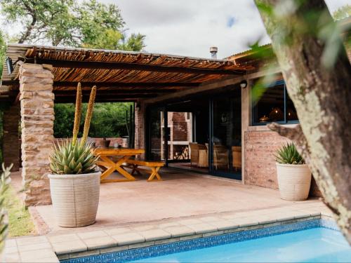 um pátio com uma pérgola de madeira e uma piscina em Klipplaatsdrift Safari Lodge em Hofmeyr