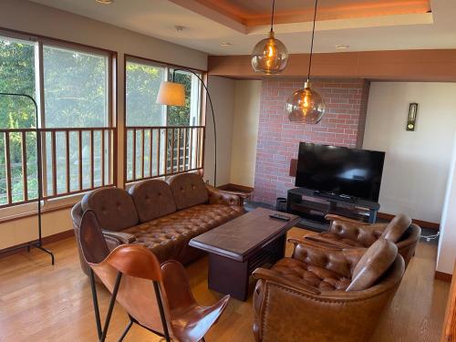 a living room with a couch and a flat screen tv at New open【Mermaid annex】最大13名可！壮大な富士山の景色を楽しむ、高級貸別荘！ in Oishi