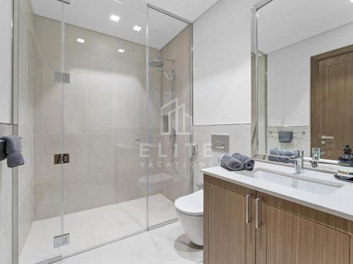 a bathroom with a shower and a toilet and a sink at Luxury 4BR Villa with Private Beach and Burj Views in Dubai