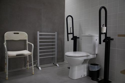 a bathroom with a toilet and a chair at Ponteloft - Xeitoso in Pontevedra