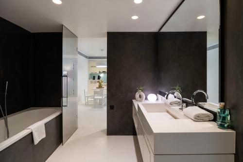 a bathroom with two sinks and a bath tub at B-aparthotel Regent in Brussels