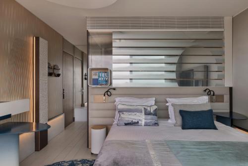 a bedroom with a large bed with pillows at Port Tower by Isrotel Design in Tel Aviv