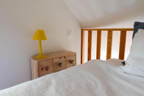 Un dormitorio con una cama y una lámpara en un tocador en Verzasca Lodge Elma, en Sonogno