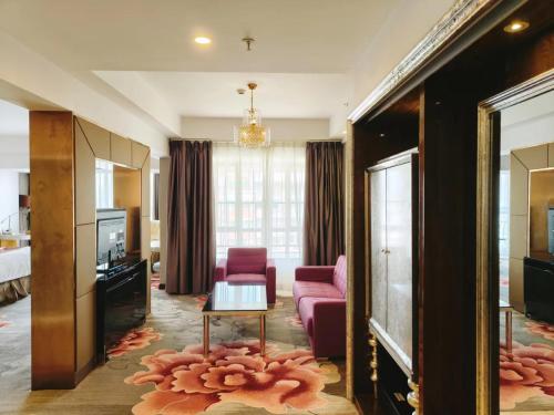 uma sala de estar com um sofá rosa e uma televisão em Clayton Hotel-Near Pazhou Exhibition Center em Guangzhou