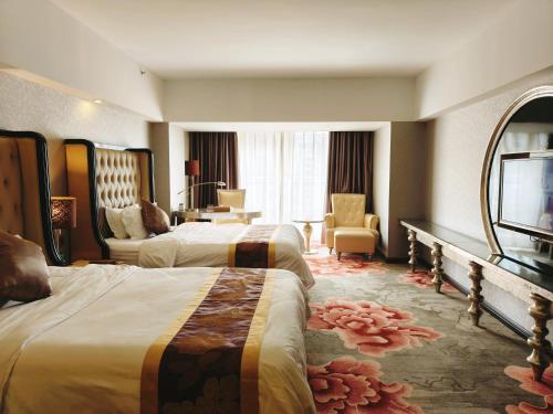 a hotel room with two beds and a television at 广州克莱顿酒店 Clayton Hotel Pazhou Exhibition Center in Guangzhou