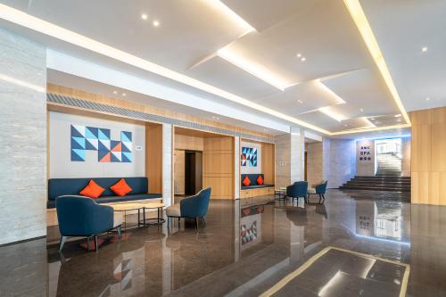 a lobby with chairs and a table in a building at Holiday Inn Express Xiamen Lushan -Shopping Center by IHG in Xiamen