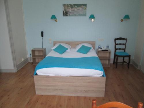 a bedroom with a bed with blue sheets and a chair at Logis Hôtel Beauséjour in Chauvigny