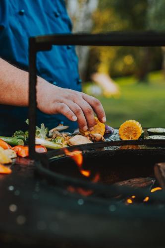 a person is cooking food on a grill at Resort Český les in Bělá nad Radbuzou