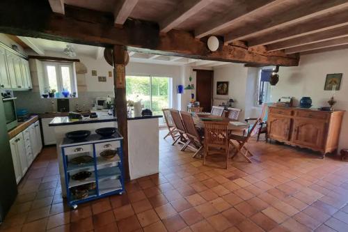 eine Küche und ein Esszimmer mit einem Tisch und Stühlen in der Unterkunft "Le Petit Breuil" near Saintes in Les Essards