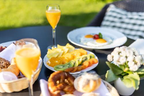 a table with plates of food and two glasses of orange juice at Hotel Adula in Flims