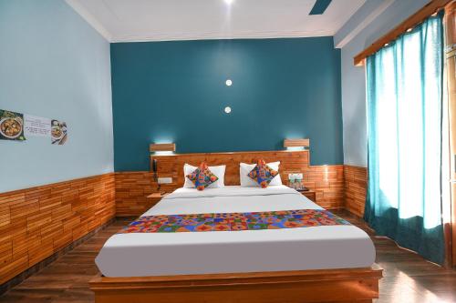 1 dormitorio con 1 cama grande y pared azul en FabHotel Snower, en Lārji