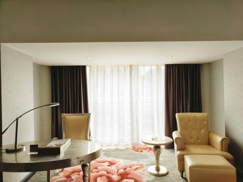 a living room with a desk and chairs and a table at 广州克莱顿酒店 Clayton Hotel Pazhou Exhibition Center in Guangzhou