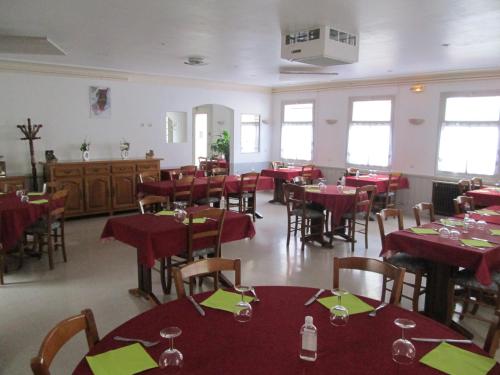a dining room with red tables and chairs at Logis Hôtel Beauséjour in Chauvigny