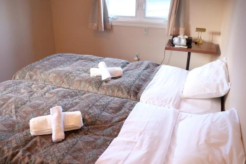 1 dormitorio con 2 toallas en una cama en ワールドカリーの館　すぱいすろーど en Matsukawa