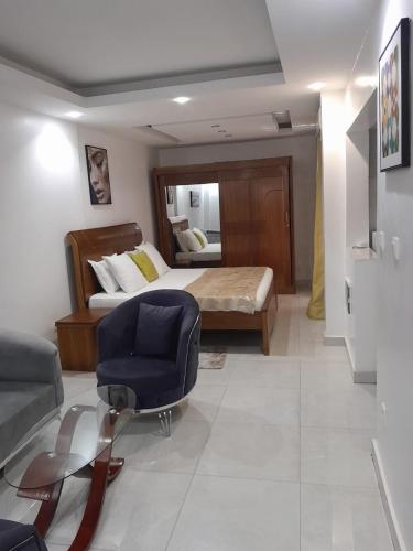 a bedroom with a bed and a chair and a couch at RESIDENCE FABY 1 in Dakar