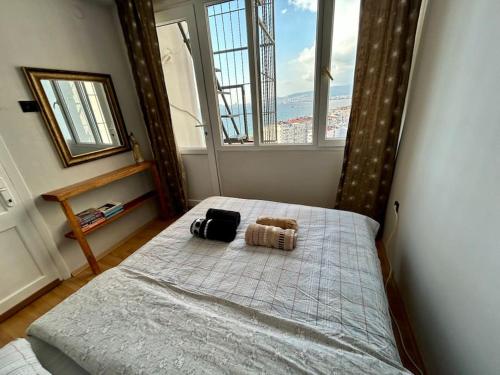 a bedroom with a bed with two bags on it at Penthouse with unique sea view and private terrace in Konak