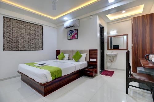 a bedroom with a large bed and a bathroom at Hotel StayBird - Nest, Kharadi in Pune