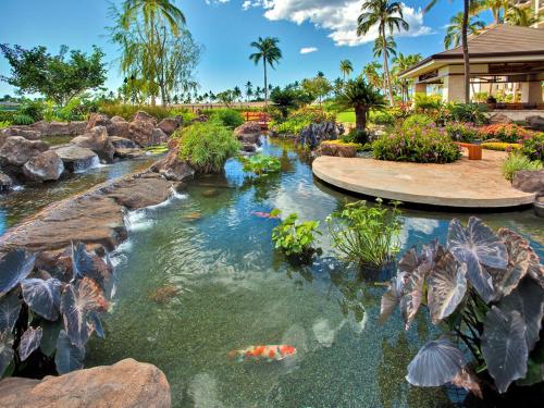 a koi pond in a garden with rocks at Ko Olina Beach Villas O1004 in Kapolei