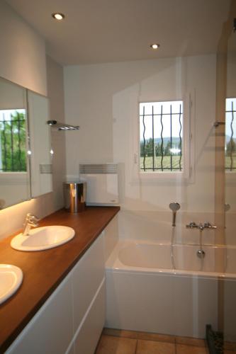 a bathroom with a tub and a sink and a bath tubermottermott at 225 Chemin des Joncs in Saint-Pierre-de-Vassols