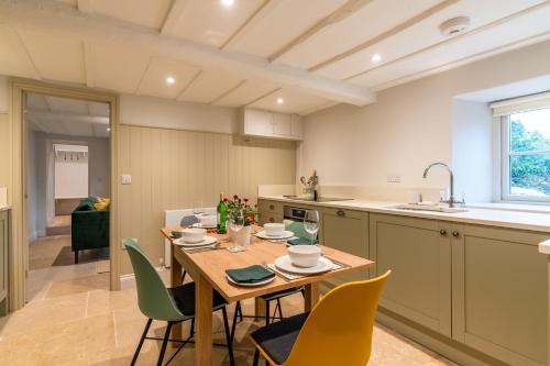 a kitchen and dining room with a table and chairs at Sloe Manor Cottage in Chipping Norton