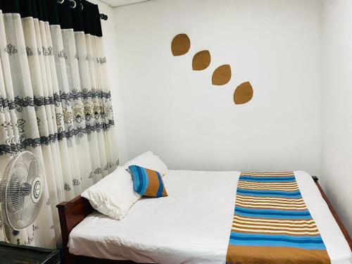 a small bedroom with a bed and a fan at JUNGLE VILLA in Galle
