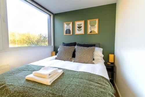 ein Schlafzimmer mit einem Bett mit zwei Handtüchern darauf in der Unterkunft 4 Bed MK Cosy & Well equipped House in Shenley Church End