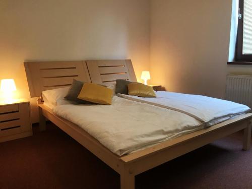 a bed with two pillows on it in a bedroom at Apartmány DOKY Holiday in Lipno nad Vltavou