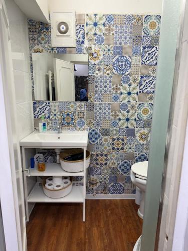 uma casa de banho com azulejos azuis e brancos na parede em inside my city em Gênova