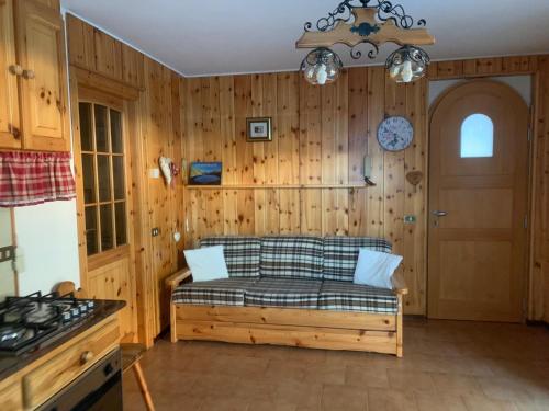 a living room with a couch and a door at CASA PIAZZALE ALPINI in Schilpario