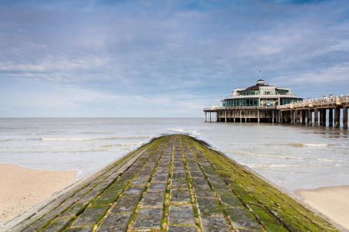 a pier on the beach next to the ocean at Cosy apartment 150m from the beach in Blankenberge