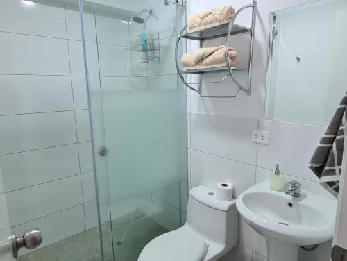 y baño con ducha, aseo y lavamanos. en Acogedor departamento con vista al mar, en Lima