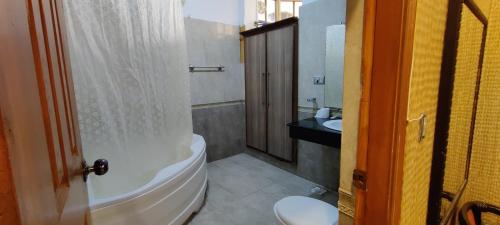 a bathroom with a tub and a toilet and a sink at Capri Executive in Islamabad