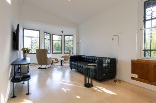 a living room with a black couch and a table at Villa Schönthaler in Semmering