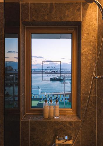 a bathroom window with four bottles on a ledge at Nampo Ocean2Heaven Hotel& Spa in Busan