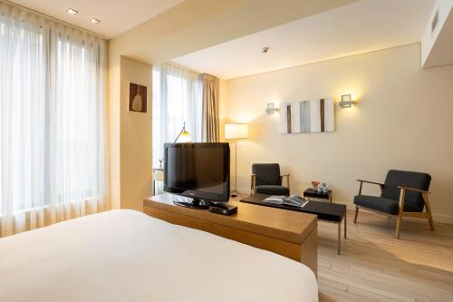 um quarto de hotel com uma cama e uma televisão de ecrã plano em B-aparthotel Grand Place em Bruxelas