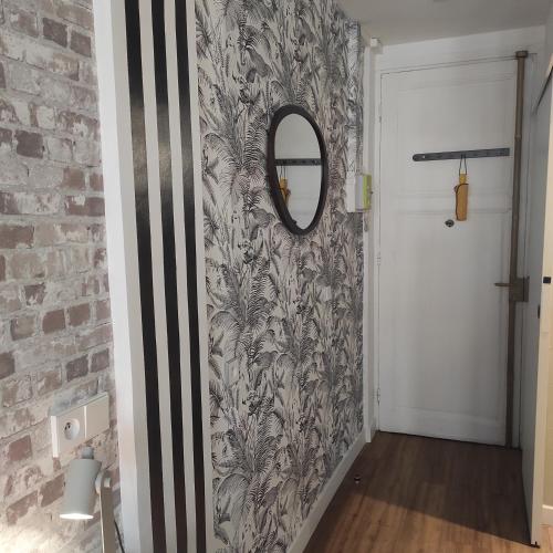 un couloir avec un mur en briques et un miroir dans l'établissement Grand studio confortable au coeur de NICE, à Nice