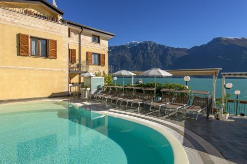 a pool at a hotel with tables and chairs at Hotel all'Azzurro in Limone sul Garda